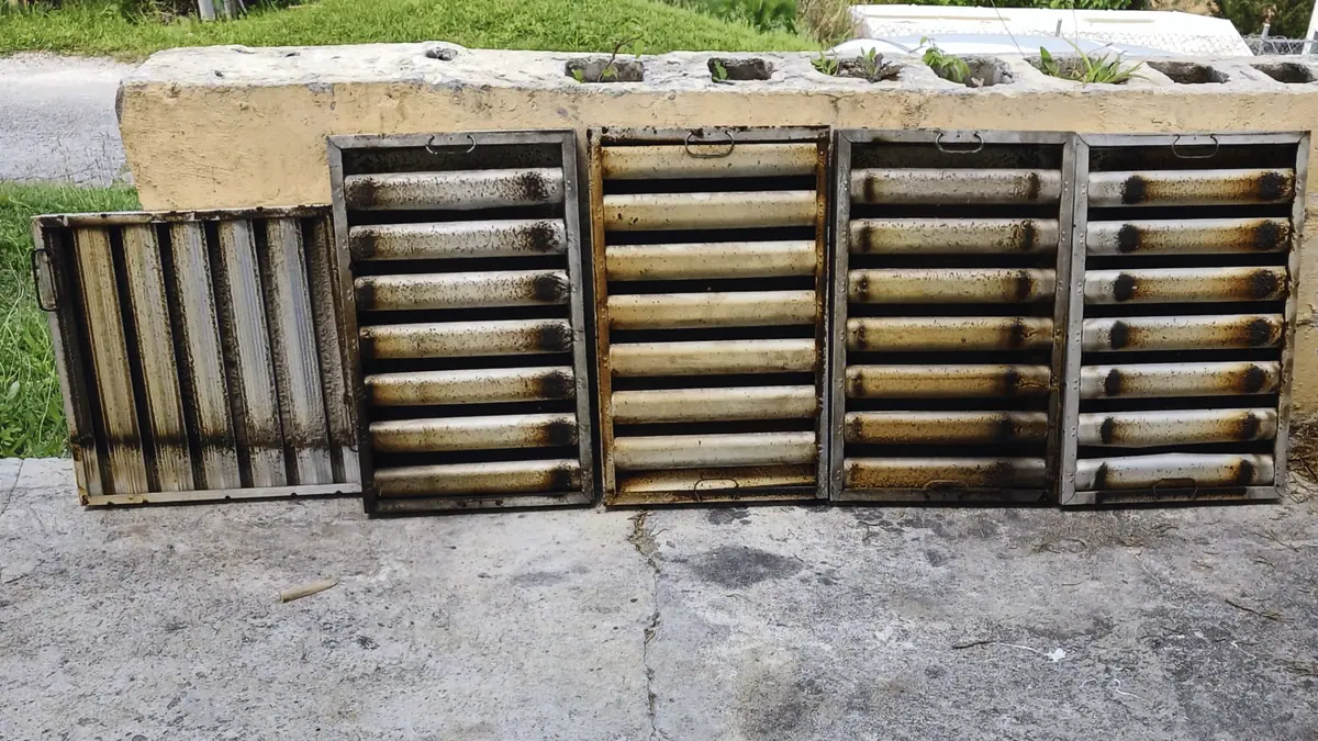 Grease filters before cleaning, coated in built-up grease and residue