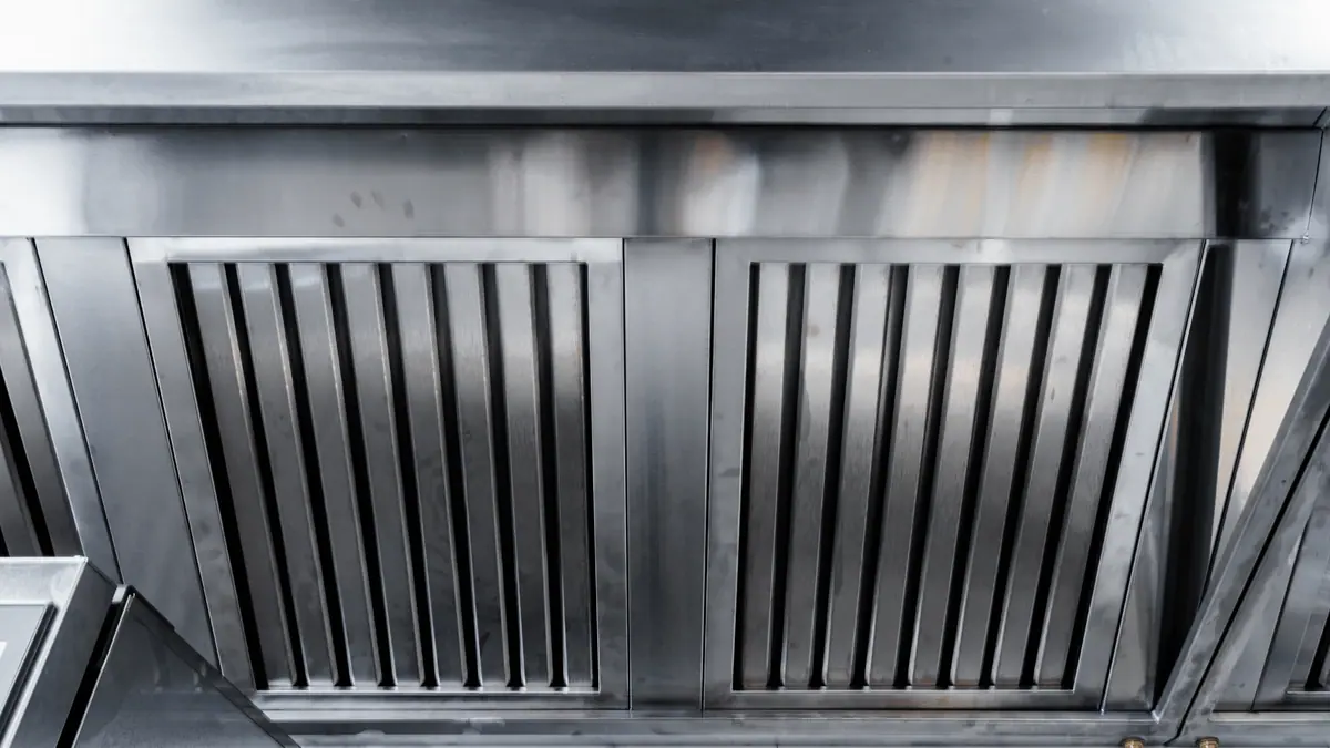 Clean grease filters newly installed in a commercial kitchen hood